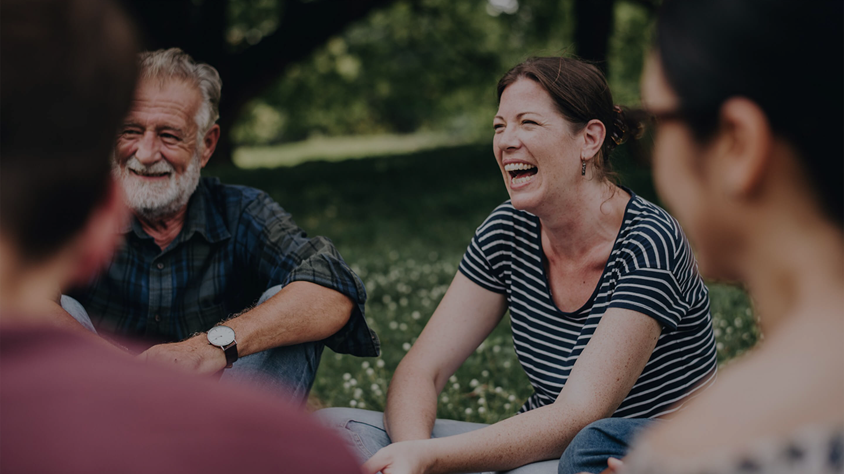 Famiglia che sorride seduta all'aperto
